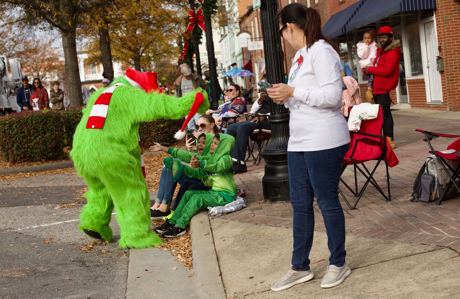 The Grinch interacts with children along the parade route.