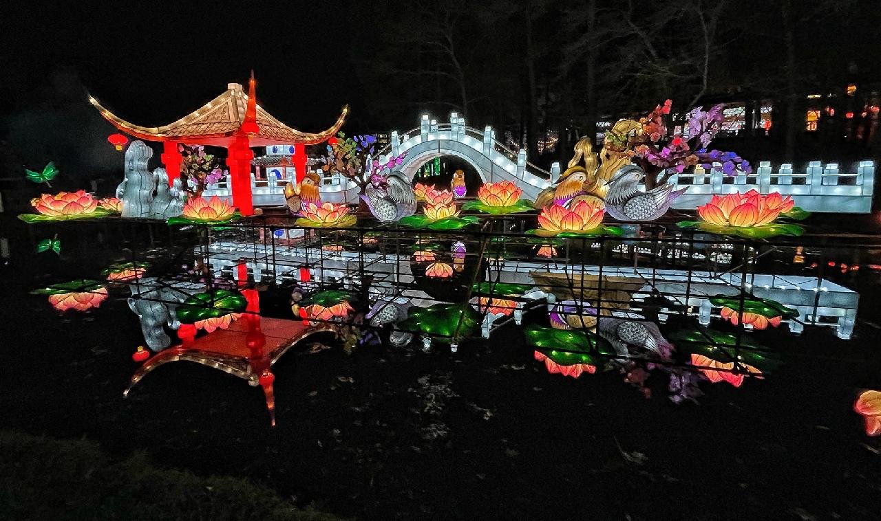 Lighted structures and figures are reflected in Symphony Lake at the Chinese Lantern Festival in Cary.