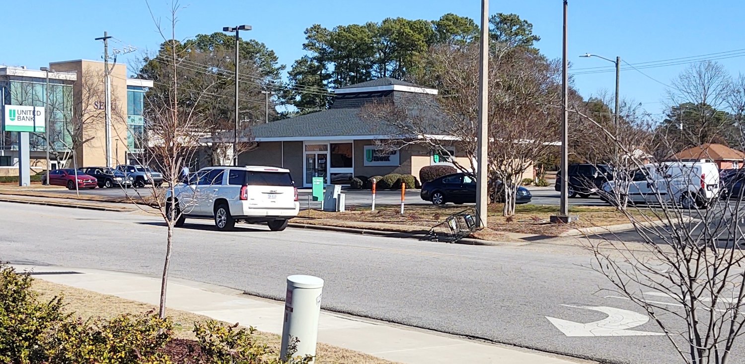 A shopping cart lies on the curb on Executive Place next to the exit to Dunkin at the Raeford Road intersection.