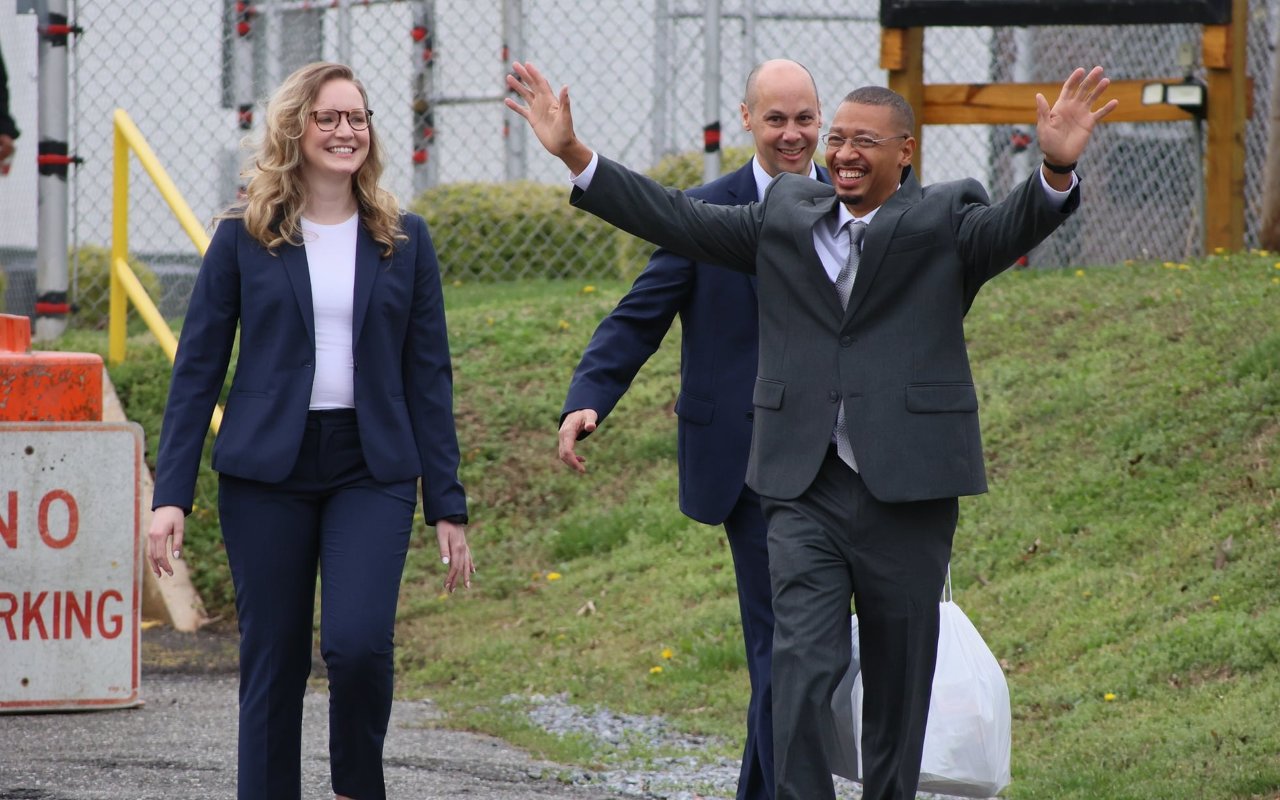 Anthony Willis raises his hands as he is released from prison on March 24. Willis is flanked by Jamie Lau, director of the NC Clemency Project, and Adelyn Curran, a former Duke University School of Law student who helped Willis gain clemency.