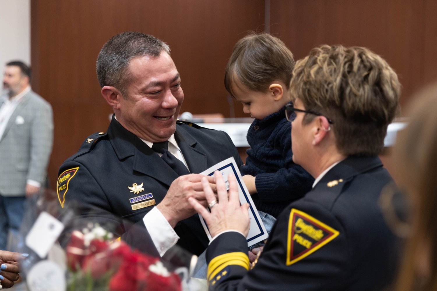 Fayetteville Police Chief Kemberle Braden holds his grandson as he speaks with Maj. Kelle Berg during Braden's swearing-in Friday afternoon.
