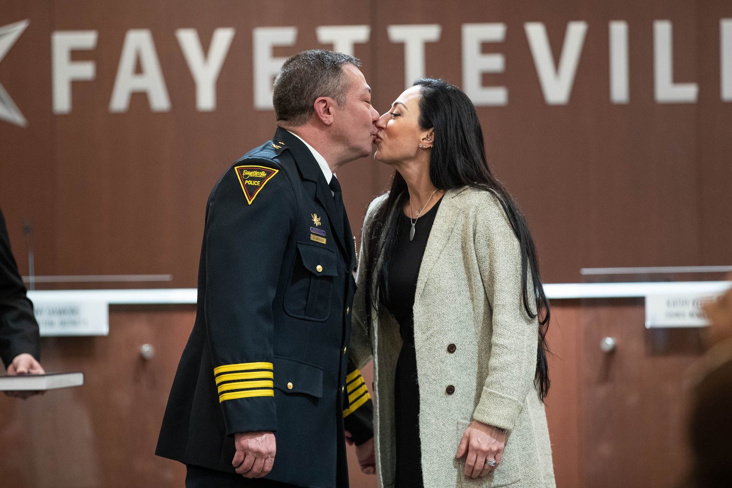 Fayetteville Police Chief Kimberle Braden and  his wife, Beth, kiss after he was sworn in Friday.