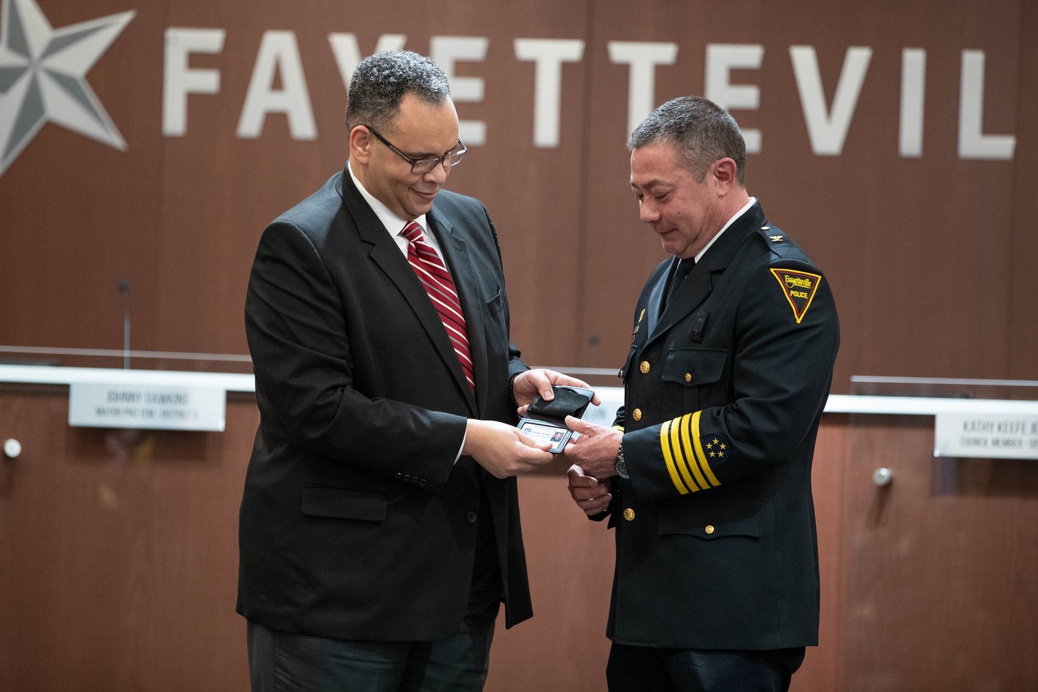 City Manager Doug Hewett presents the police chief's badge to Kimberle Braden on Friday at City Hall.