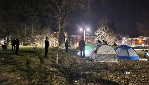 Asheville Police Department officers approach tents prior to clearing Aston Park in April 2021.