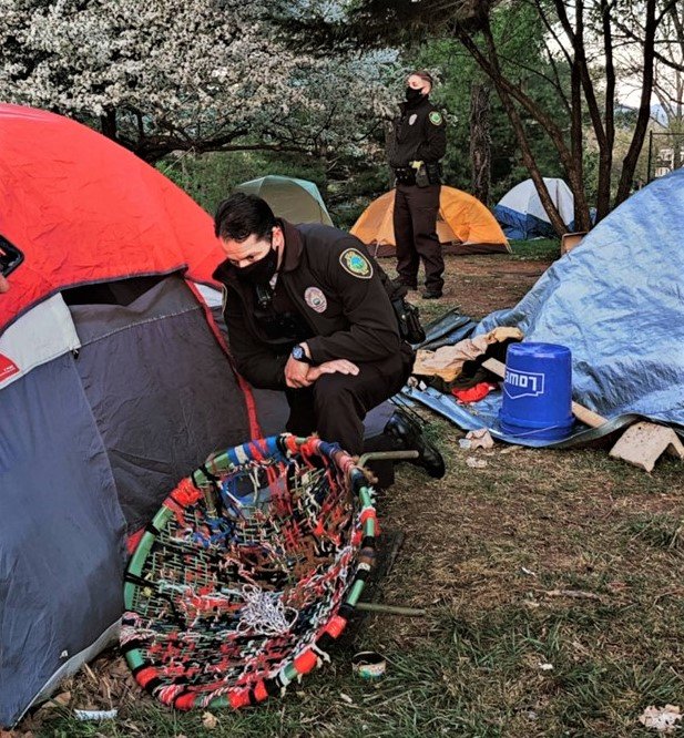 Asheville Police Department officers approach tents prior to clearing Aston Park in April 2021.