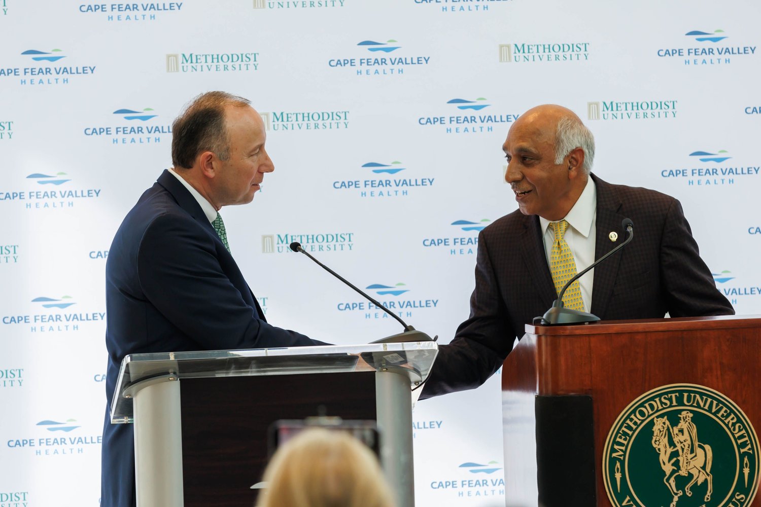Mike Nagowski, left, CEO of Cape Fear Valley Health, and Dr. Rakesh Gupta, chairman of the Methodist University board of trustees, address a news conference Monday to announce plans to partner on opening a medical school.