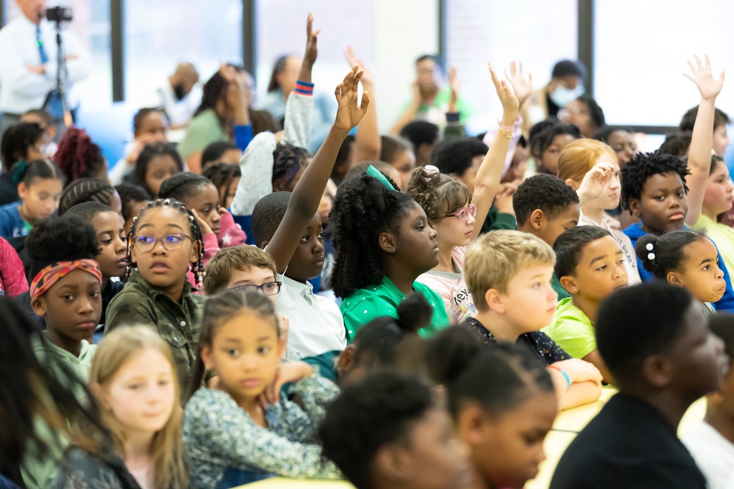 Children raise their hands to get Super Bowl champion and Fayetteville native Joshua Williams' attention at Loyd Auman Elementary School on Thursday.