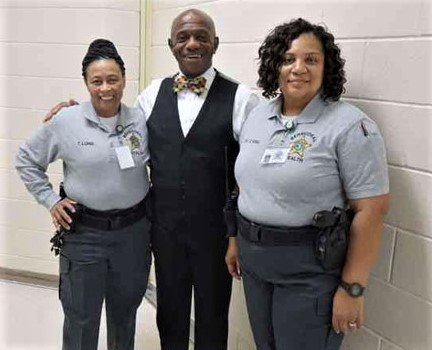 Mecklenburg County Sheriff Garry McFadden, center, visits with two specially trained behavioral health unit guards.