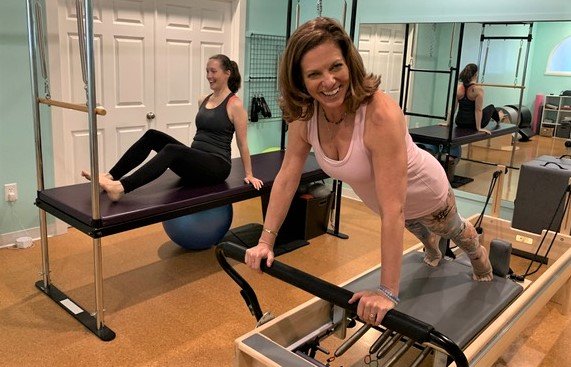 Angie Toman works out on the Pilates Reformer mat for muscle strength.