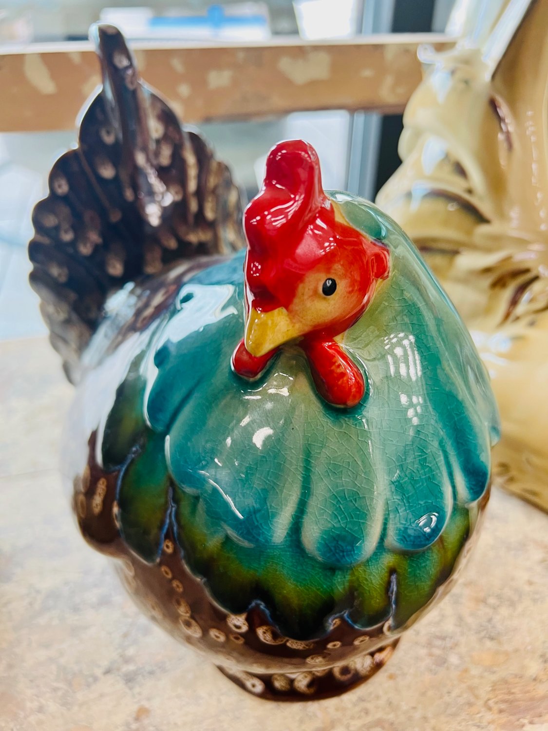 A ceramic chick is perched on a shelf.