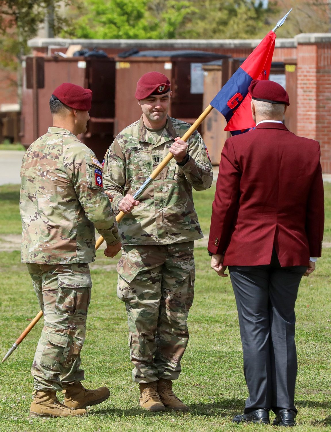 Lt. Col. Leif Thaxton, commander of Headquarters and Headquarters Battalion, 82nd Airborne Division, passes the guidon to Capt. Adam Johnson, commander of Gainey Company during the uncasing ceremony of Gainey Company on Fort Bragg on Wednesday.