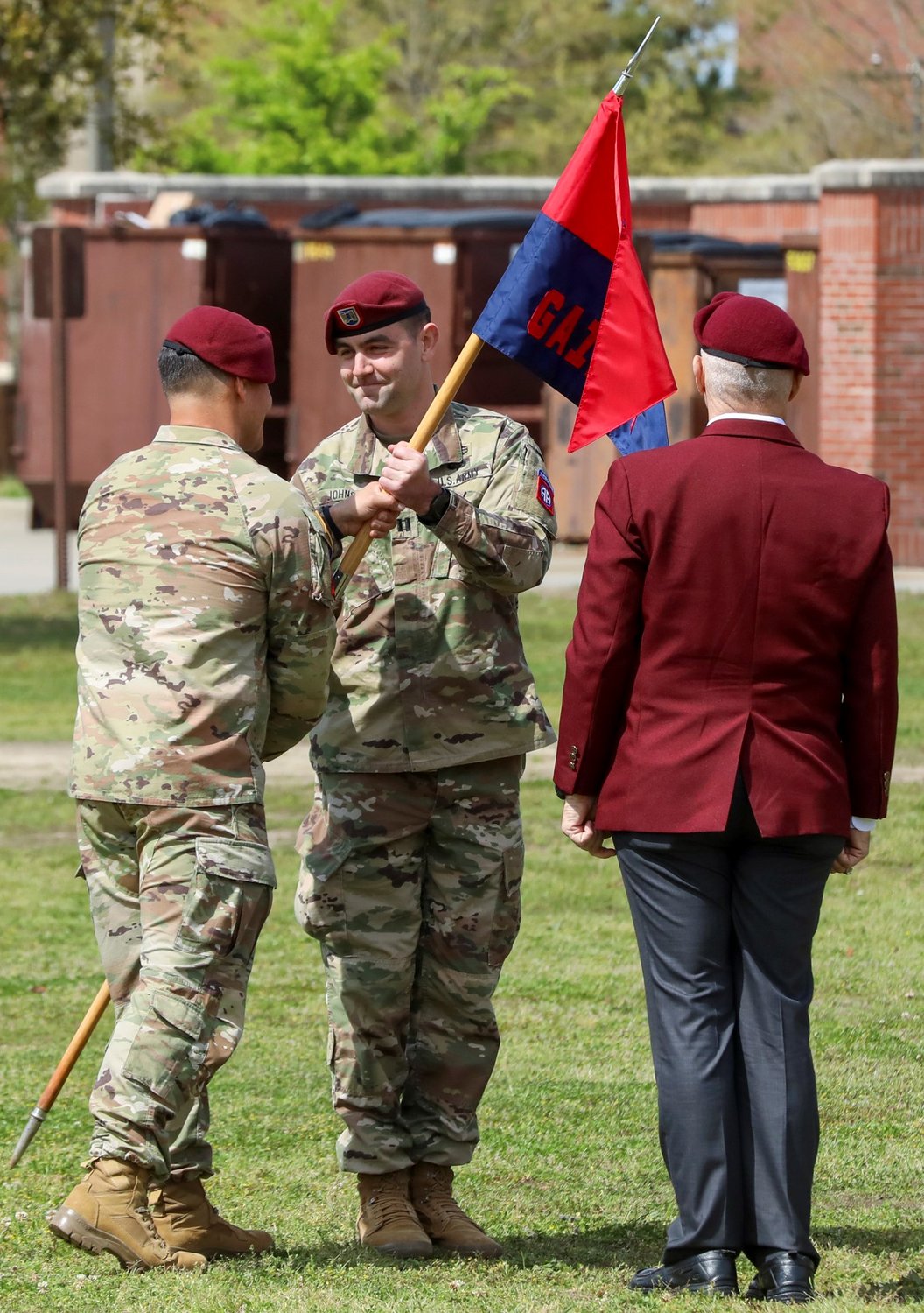 Lt. Col. Leif Thaxton, commander of Headquarters and Headquarters Battalion, 82nd Airborne Division, passes the guidon to Capt. Adam Johnson, commander of Gainey Company, during the uncasing ceremony of Gainey Company on Fort Bragg on Wednesday.