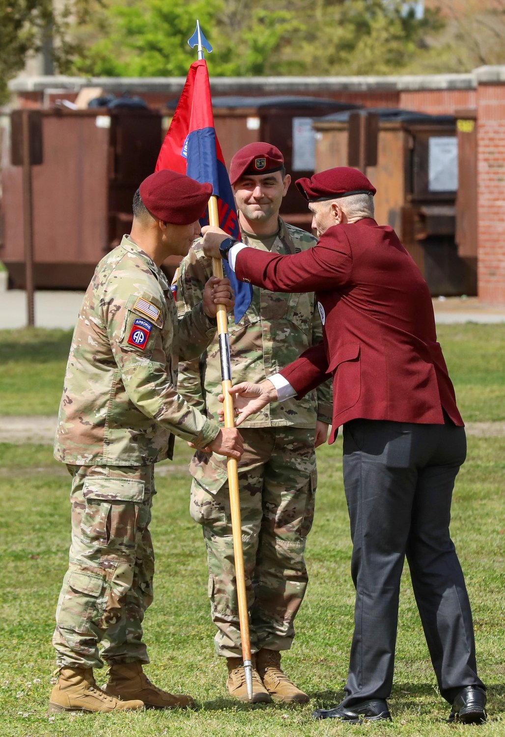 Retired Command Sgt. Maj. William J. Gainey passes the guidon to Lt. Col. Leif Thaxton, commander of Headquarters and Headquarters Battalion, 82nd Airborne Division, during the uncasing ceremony of Gainey Company on Fort Bragg on Wednesday.