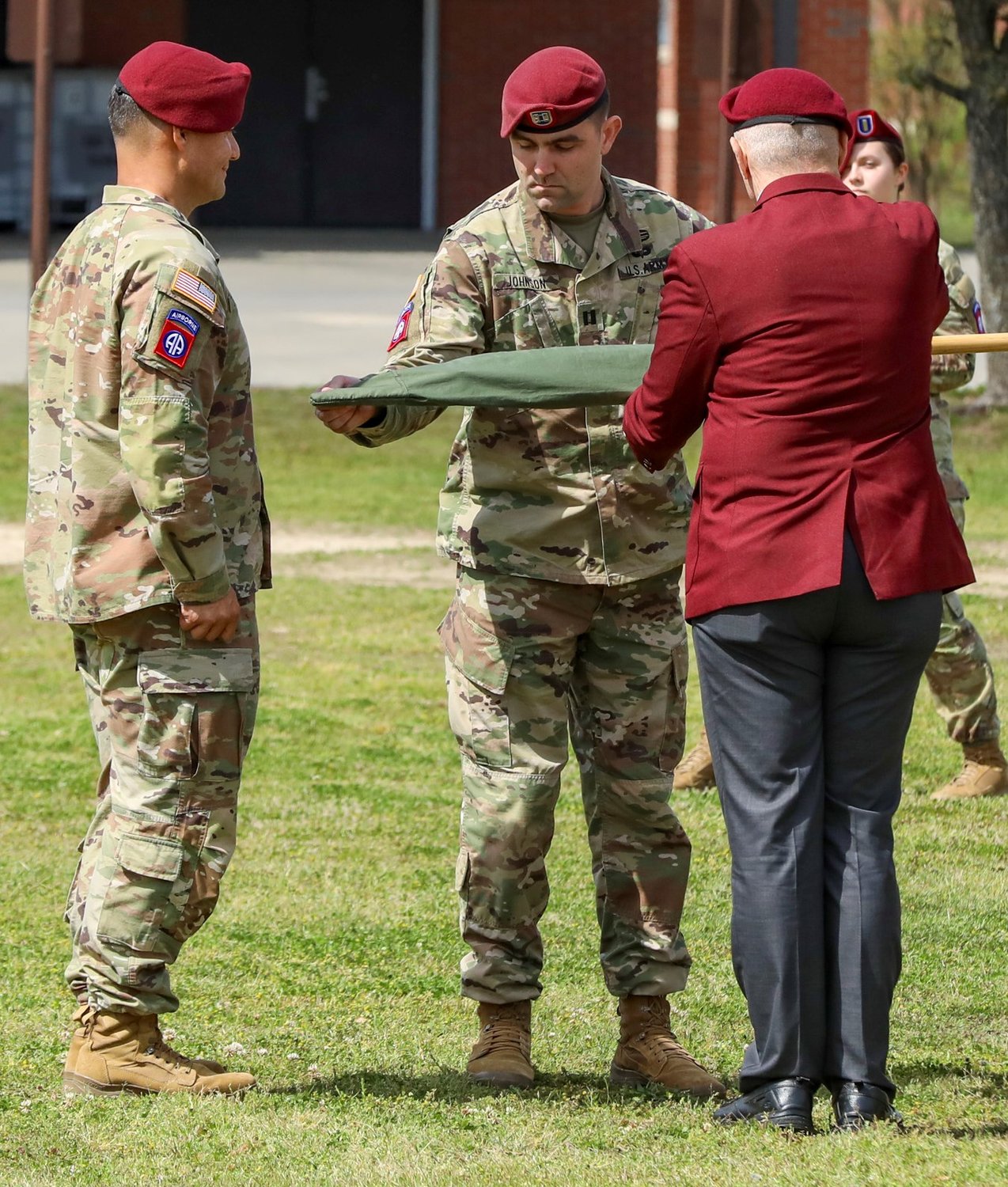 Capt. Adam Johnson, commander of Gainey Company, Headquarters and Headquarters Battalion, 82nd Airborne Division, uncases the guidon during a ceremony on Fort Bragg on Wednesday.