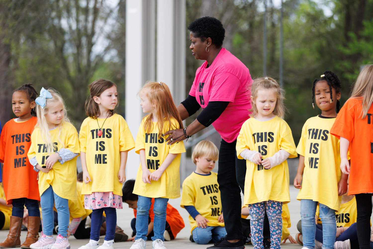Verenda Luttrell, a preschool teacher with Snyder Learning Center, positions students for a performance at Festival Park in celebration of a pinwheel garden.