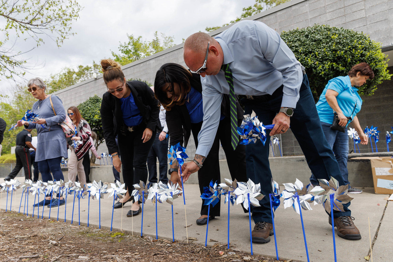 Members of law enforcement agencies plant pinwheels at Festival Park in recognition of April as Child Abuse Prevention Month.