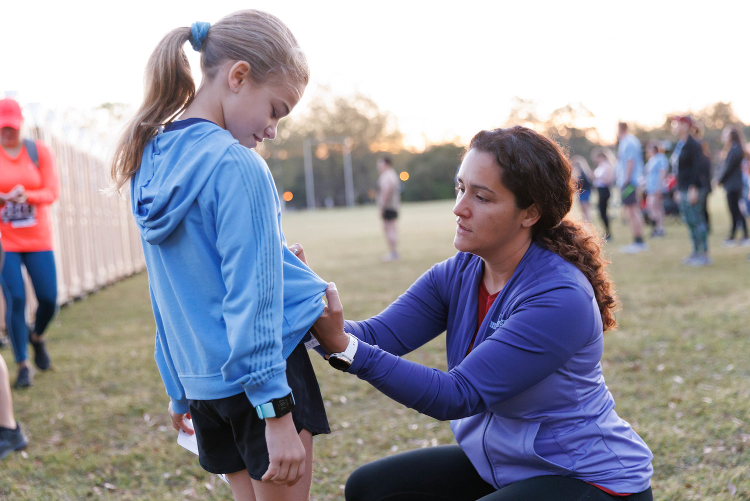 Meagan Pitts pins her daughter Abigail's bib before the start of the All American Races on  Fort Bragg on March 25, 2023.  Tony Wooten/CityView Media