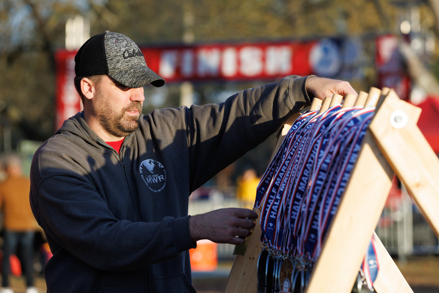 James Day of Fort Bragg MWR arranges medals for participants of the All American Races on March 23, 2023.  Tony Wooten/CityView Media