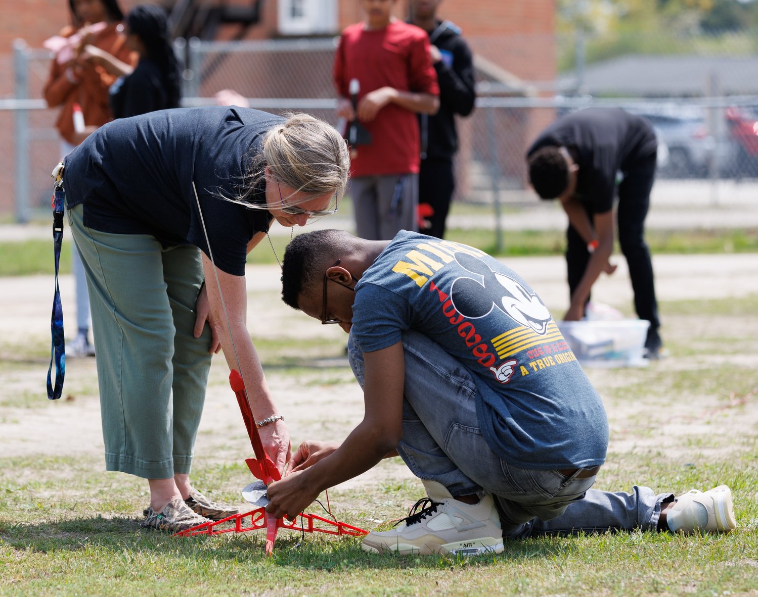 A teacher helps a student ready a rocket for launch at Seventy-First Classical Middle School.