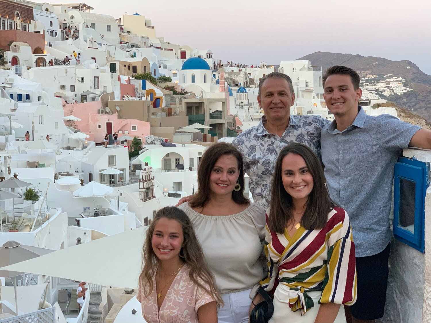 The Kalevas family — Greg, Effie, Petroula, Vasili and Athanasia — stand in historic Santorini, Greece.