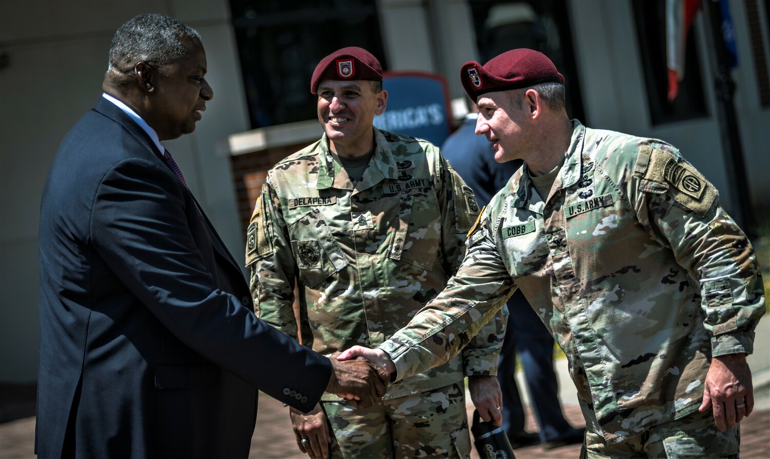 Secretary of Defense Lloyd J. Austin III is greeted by Col. Adam Cobb, chief of staff of the 82nd Airborne Division, and dIvisional Command Sgt. Maj. Randolph Delapena during a visit to Fort Bragg on Friday.