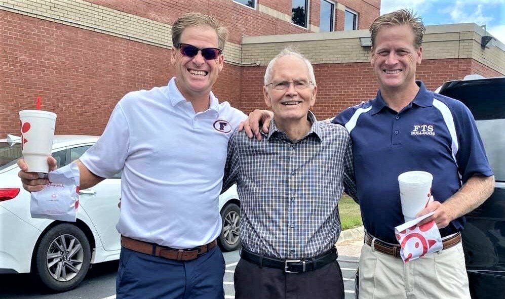 The Collins twins, Chip, left, and Chris, stand with former Terry Sanford tennis coach Gil Bowman at ceremony naming Terry Sanford tennis courts for Bowman.