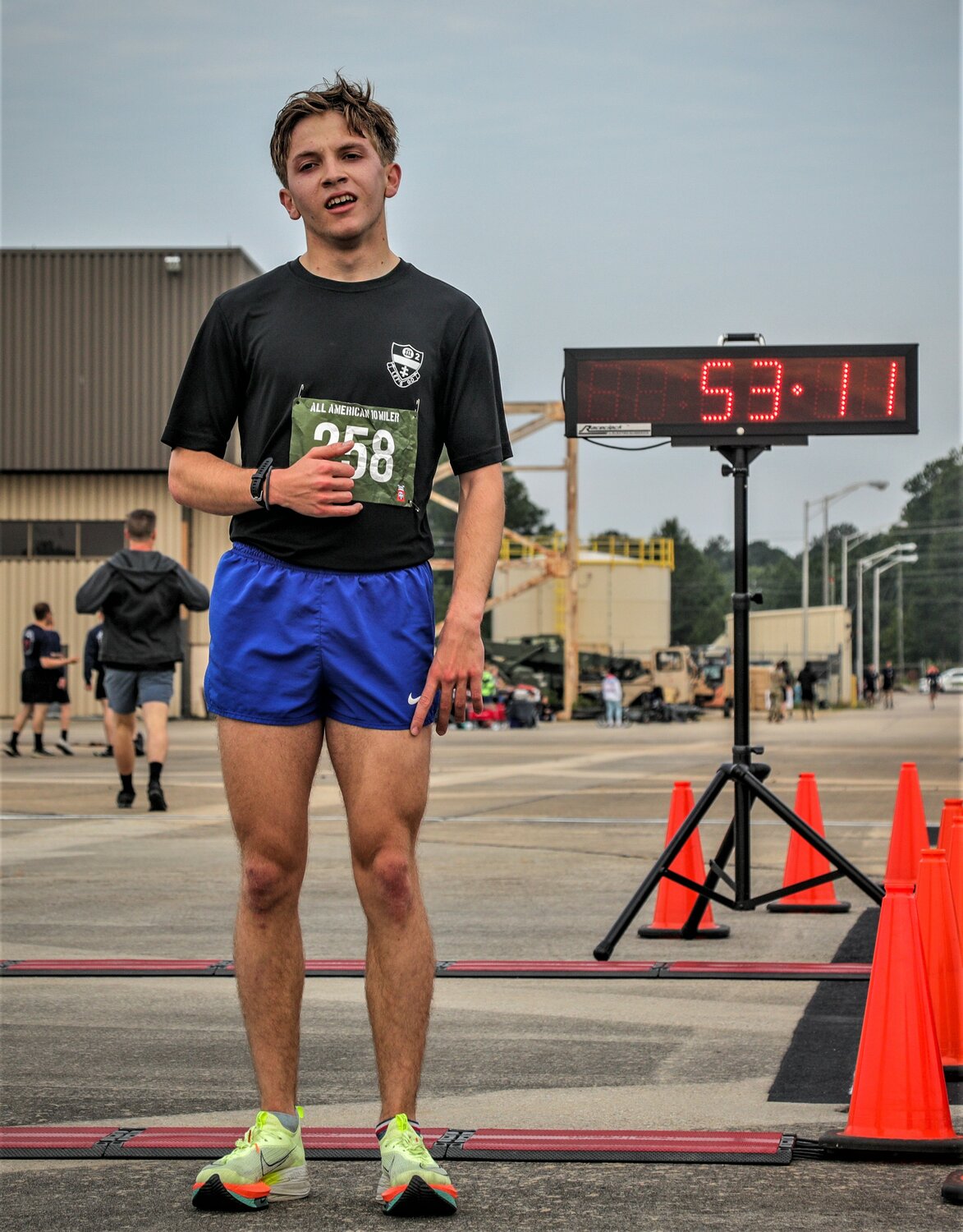 A paratrooper assigned to the 82nd Airborne Division stands next to a race clock after completing the All American 10-Miler Tuesday on Fort Bragg.
