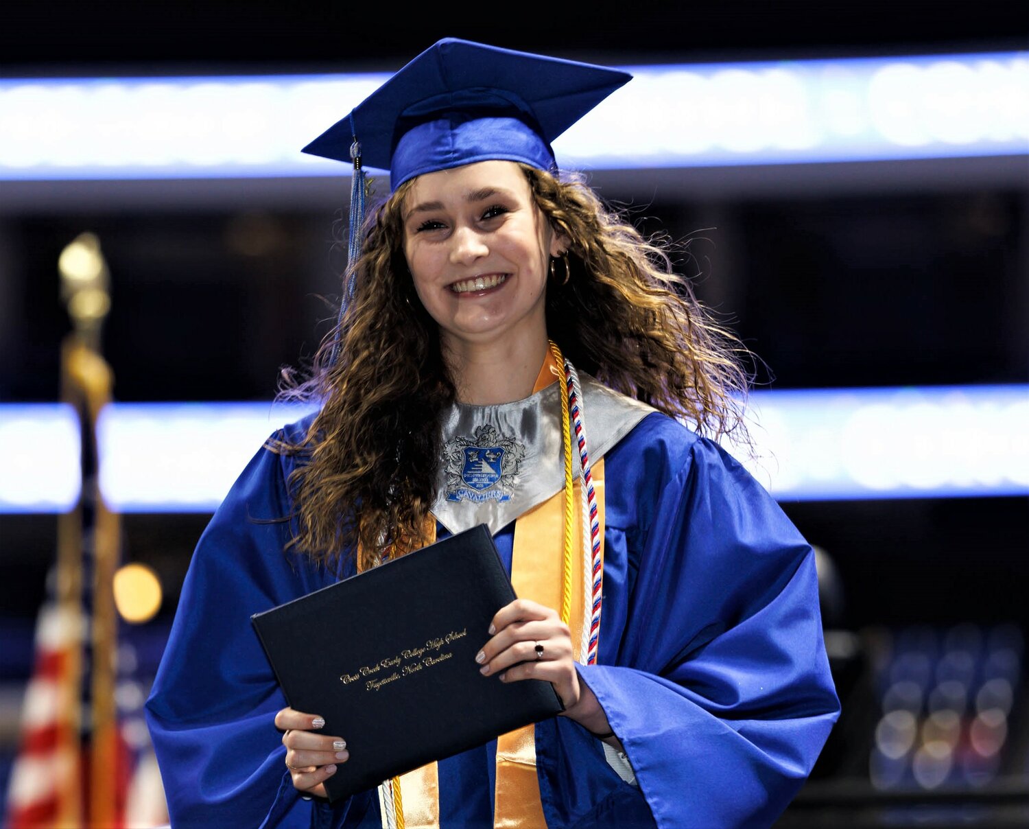 A graduate shows off her diploma at the Cross Creek Early College High School on Thursday at the Crown Coliseum.