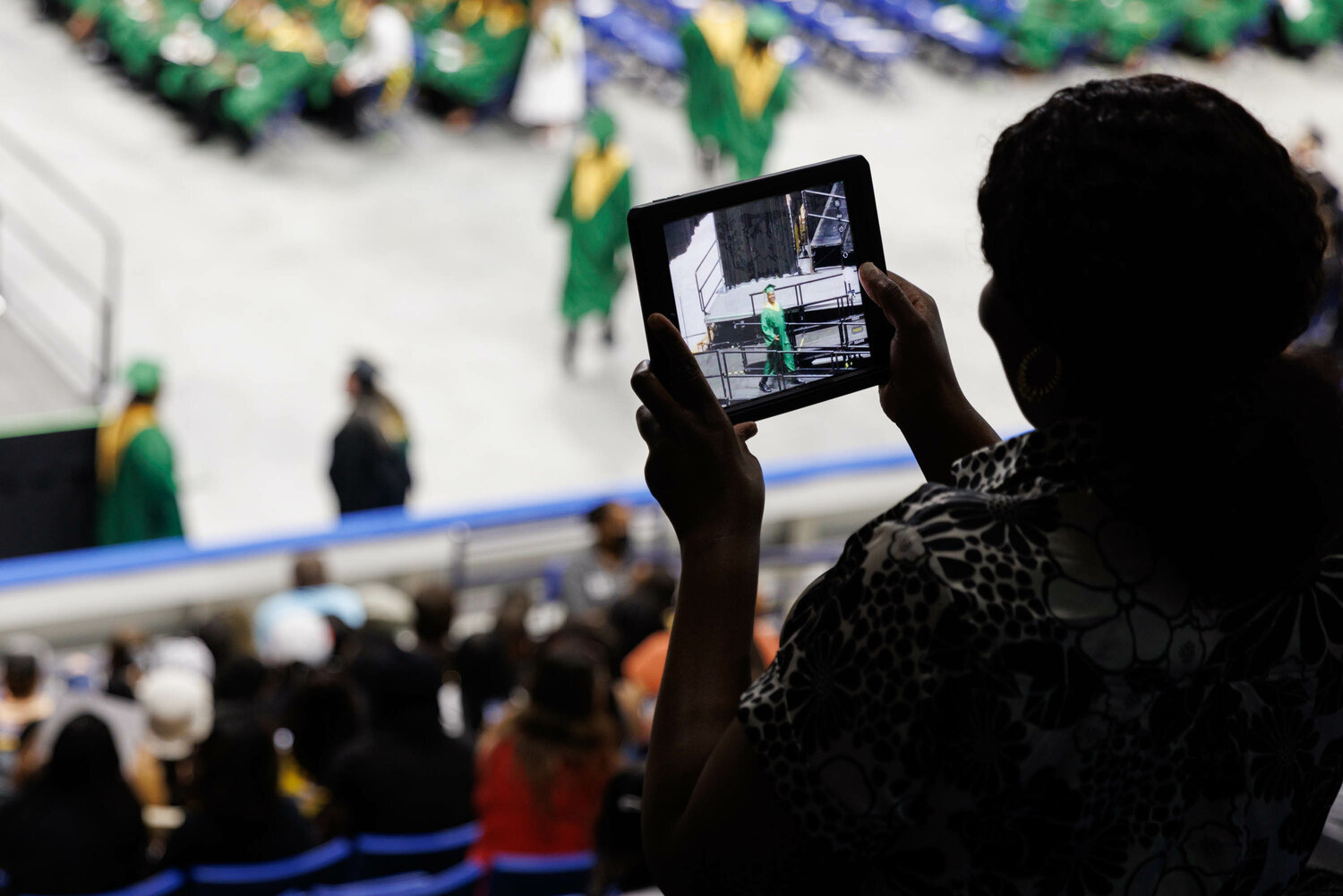 A spectator captures video of the Pine Forest High School commencement Monday in the Crown Coliseum.