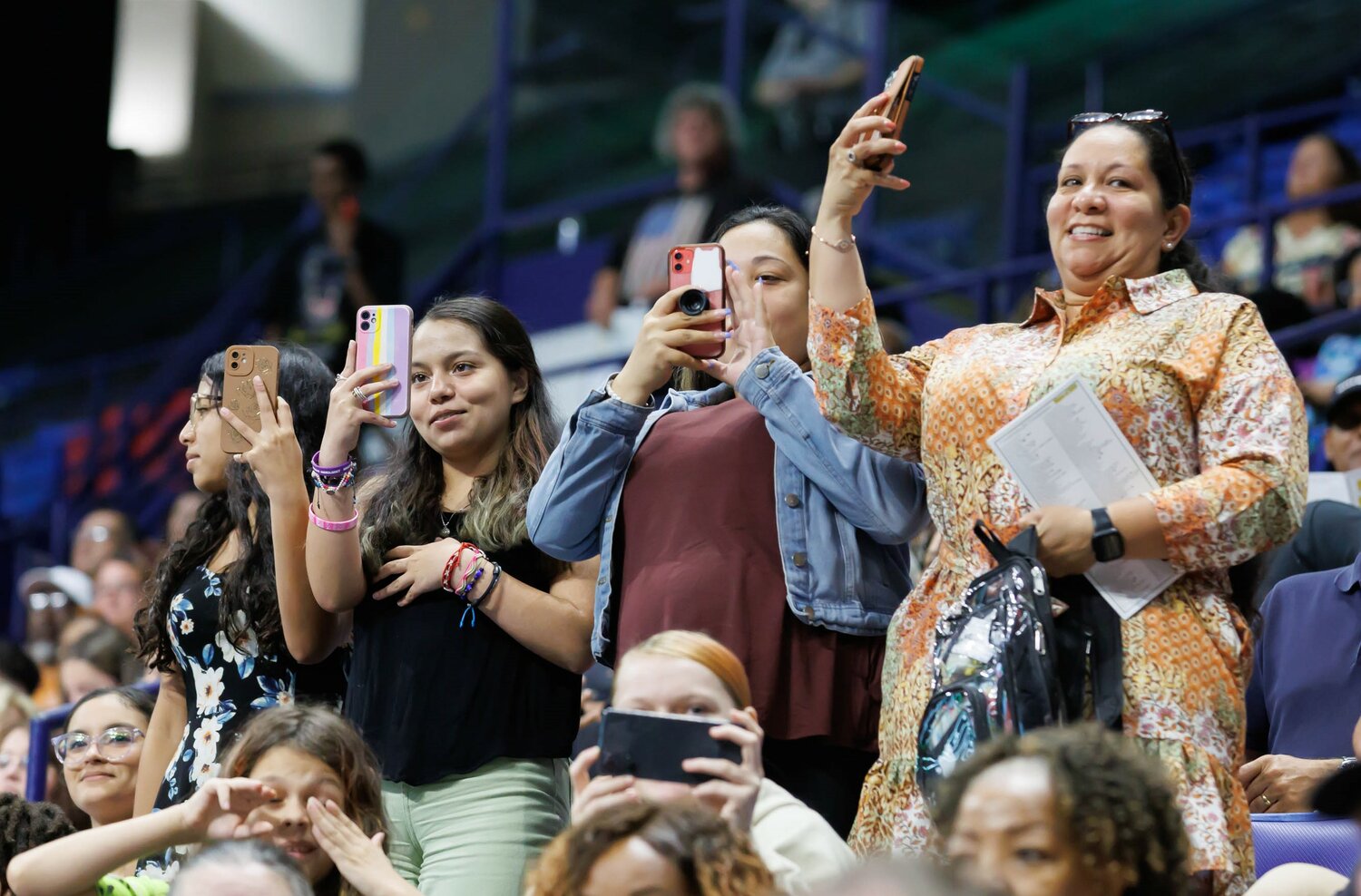 Spectators capture cellphone video of the Pine Forest High School commencement Monday in the Crown Coliseum.