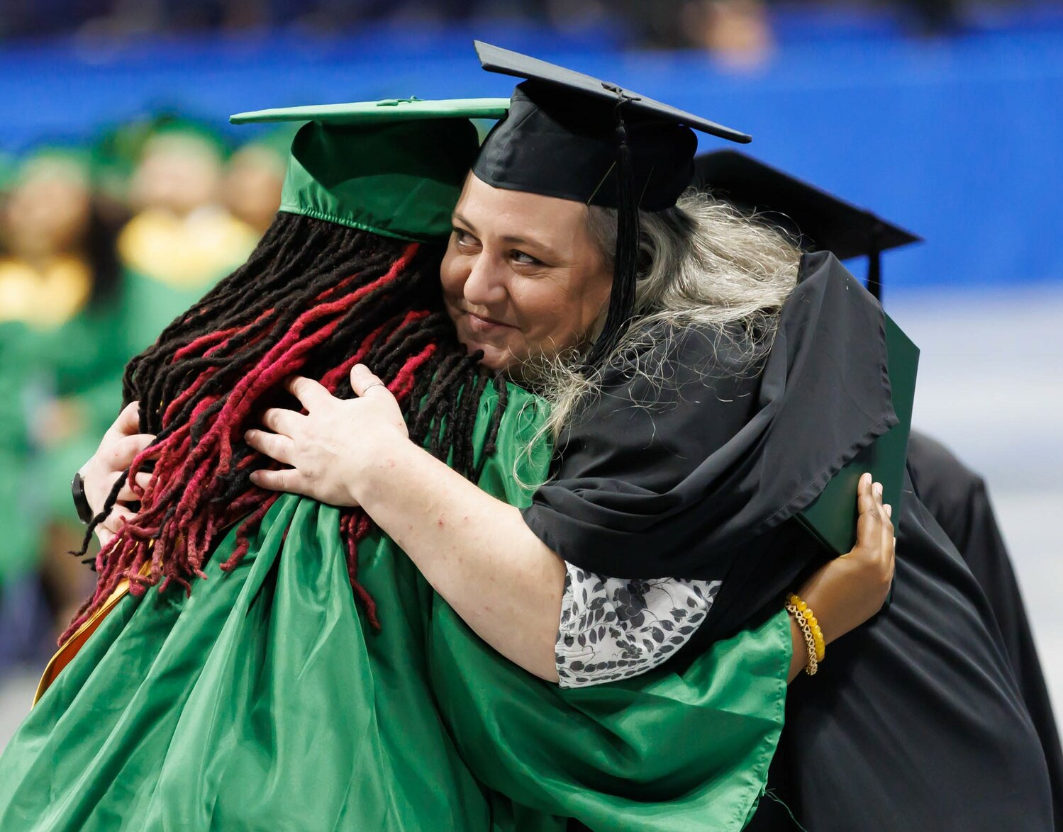 A Pine Forest High School graduate is all hugs at commencement Monday in the Crown Coliseum.