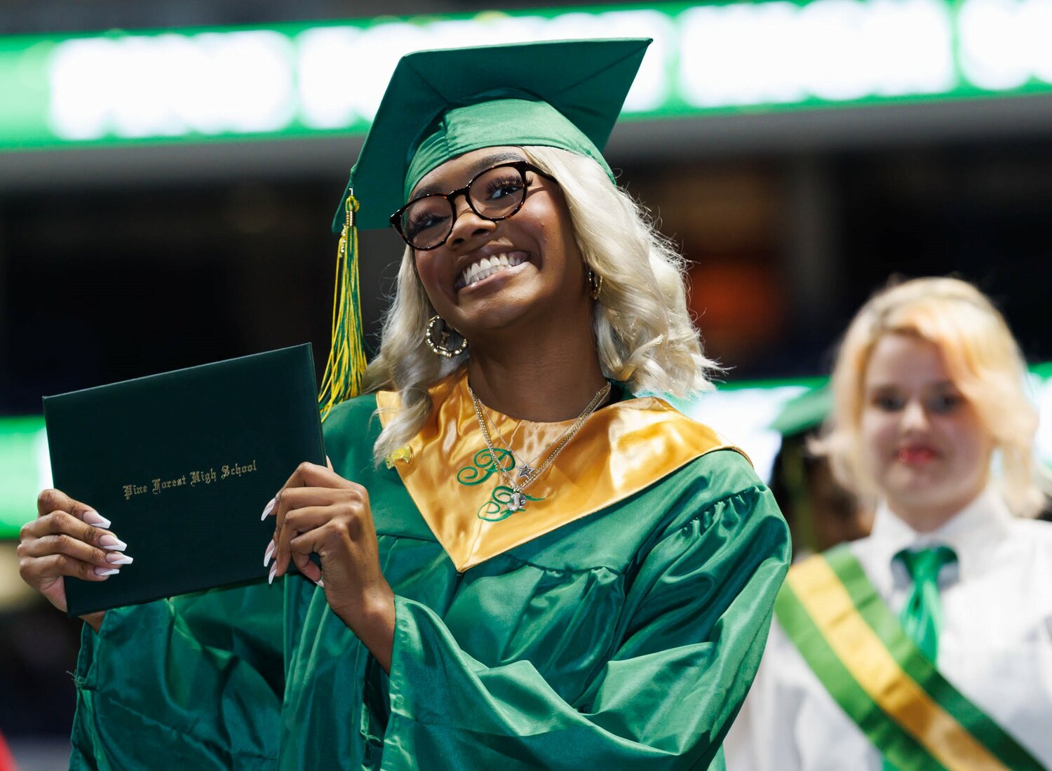 A proud graduate shows off her diploma at Pine Forest High School's commencement Monday in the Crown Coliseum.