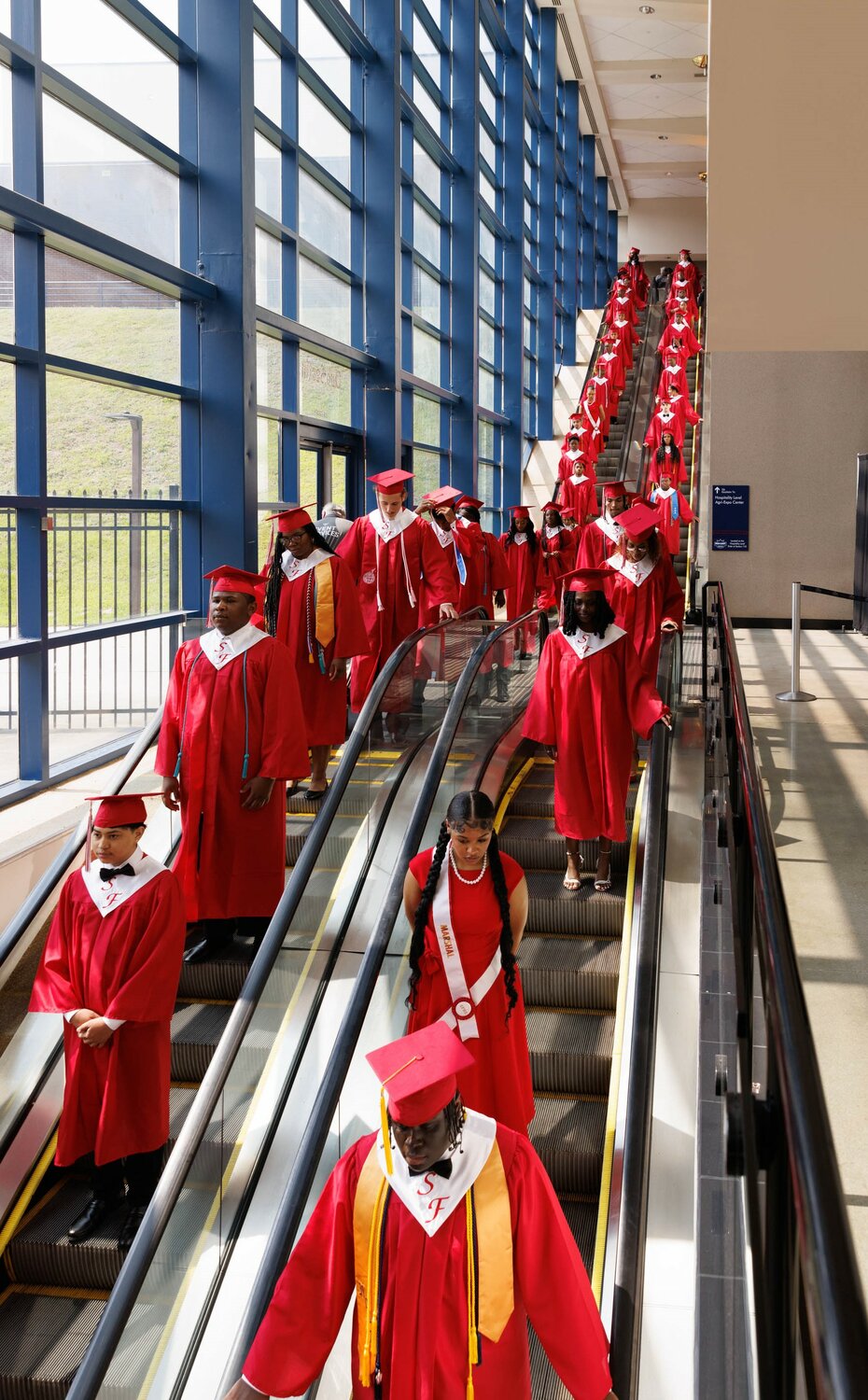 Graduates descend the escalators for the 2023 commencement for Seventy-First High School on Tuesday at the Crown Coliseum.