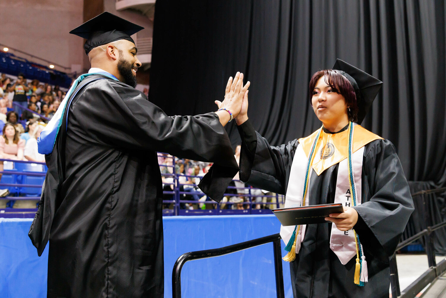 A graduate gets a high-five as South View High School holds its 2023 commencement Tuesday at the Crown Coliseum.