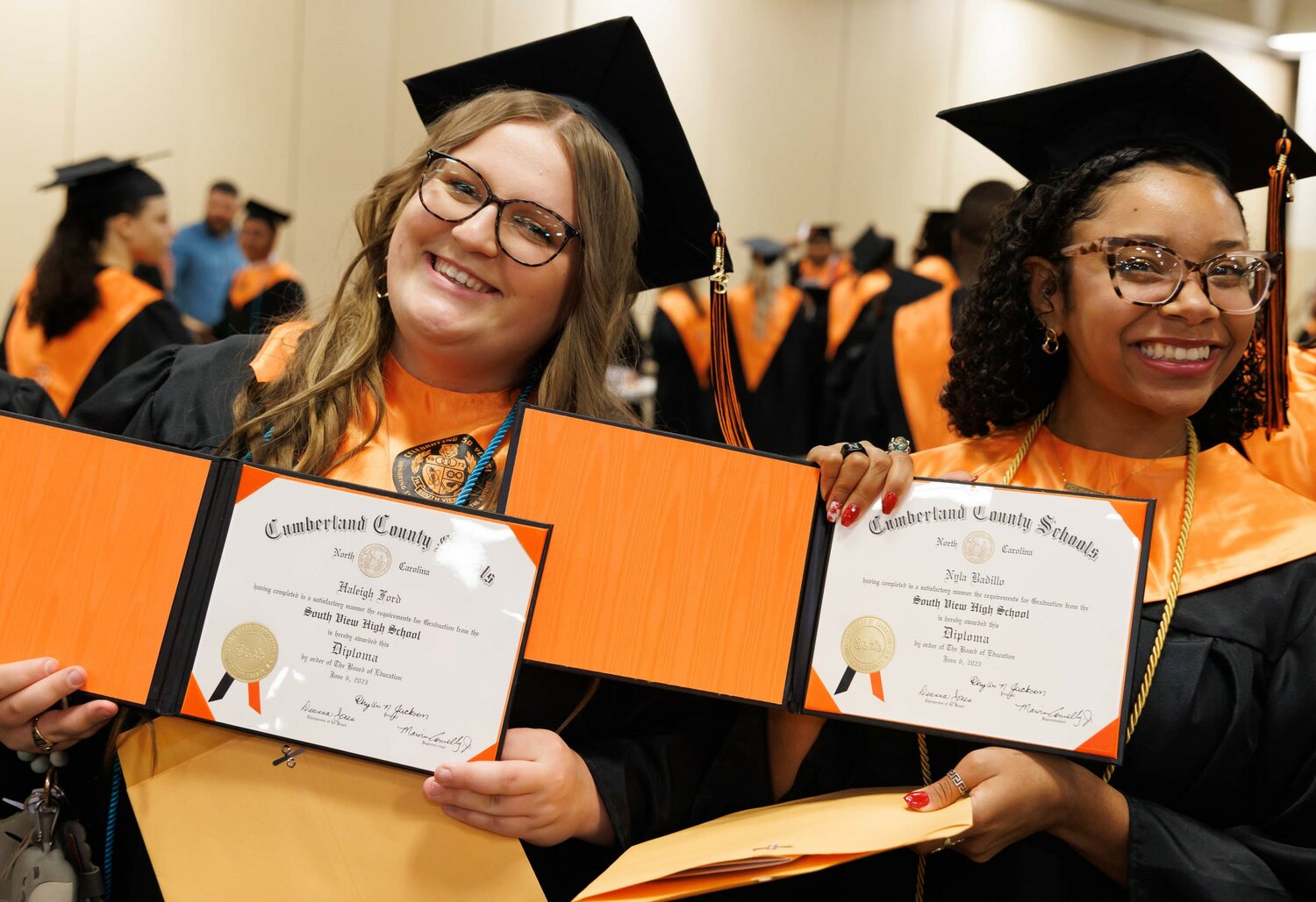 Two graduates show off their diplomas at South View High School's 2023 commencement Tuesday at the Crown Coliseum.