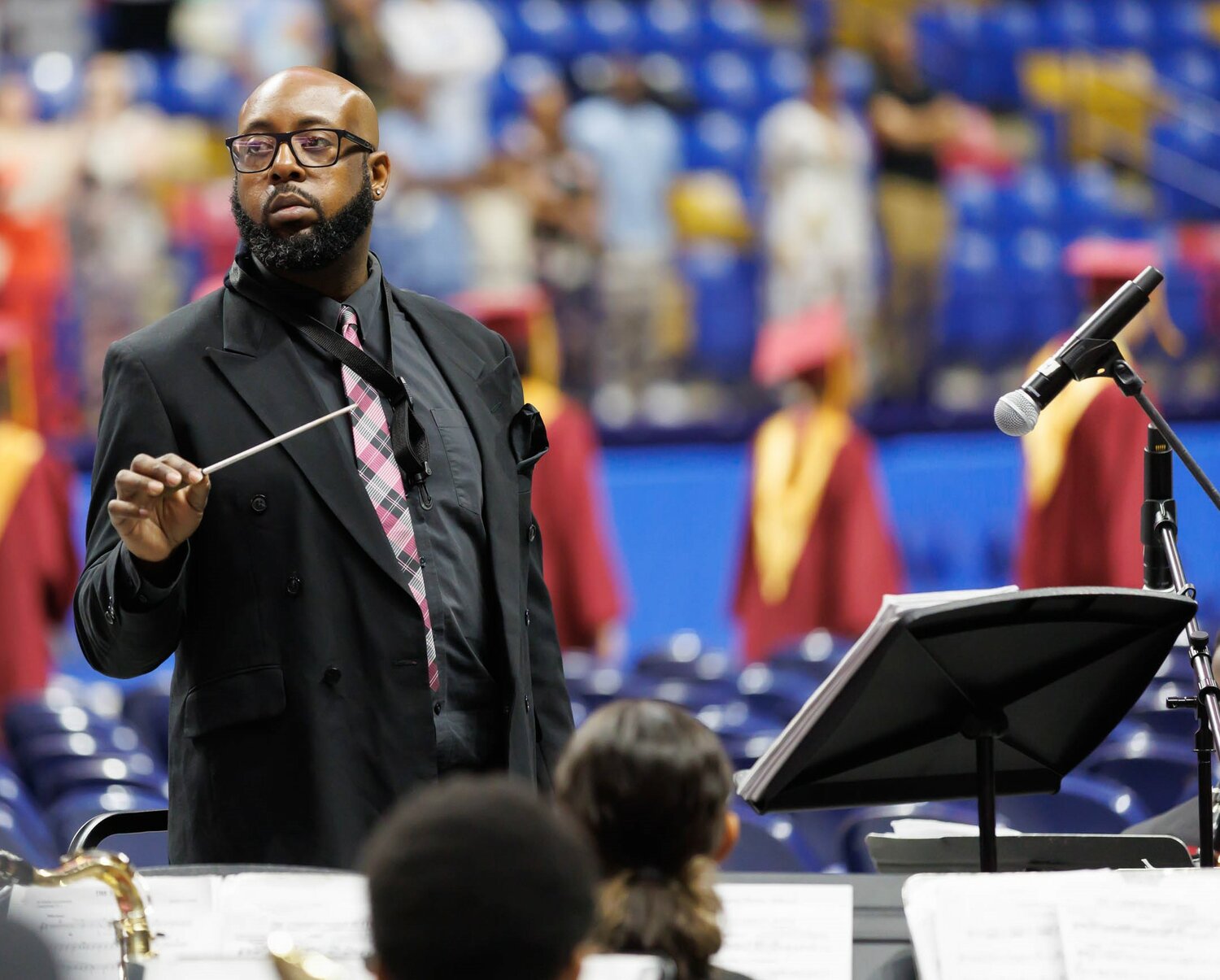 The director leads the band at the Douglas Byrd High School 2023 commencement Wednesday at the Crown Coliseum.