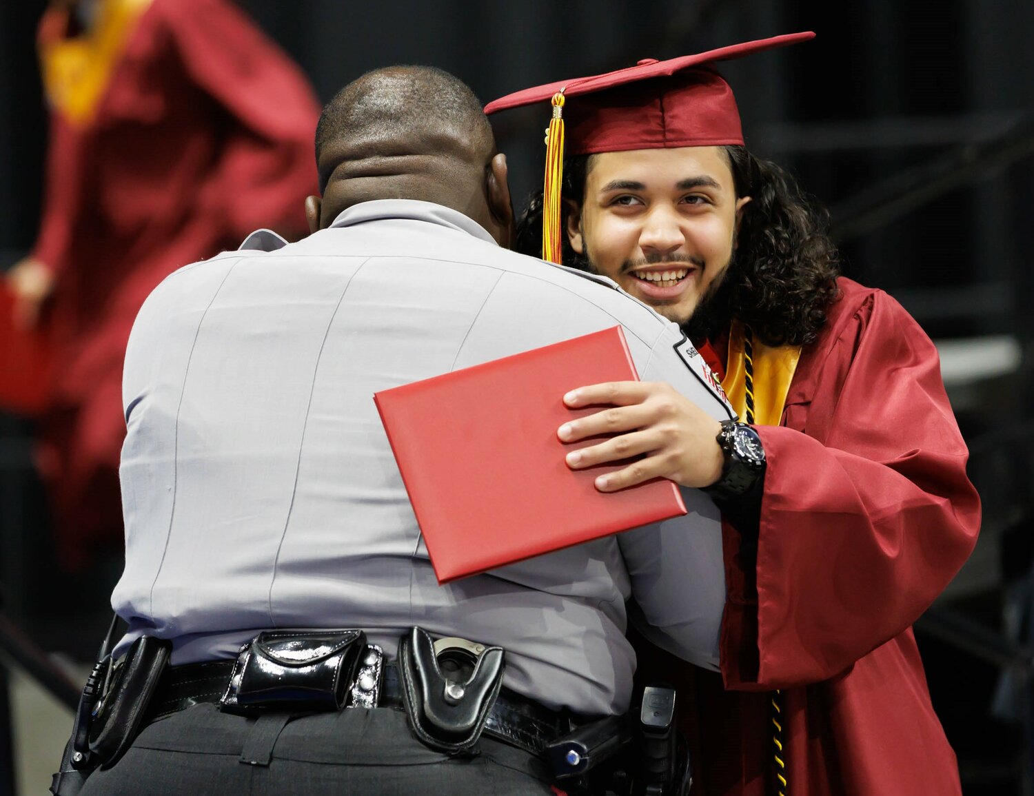 A graduate gets a bear hug at the Douglas Byrd High School 2023 commencement Wednesday at the Crown Coliseum.