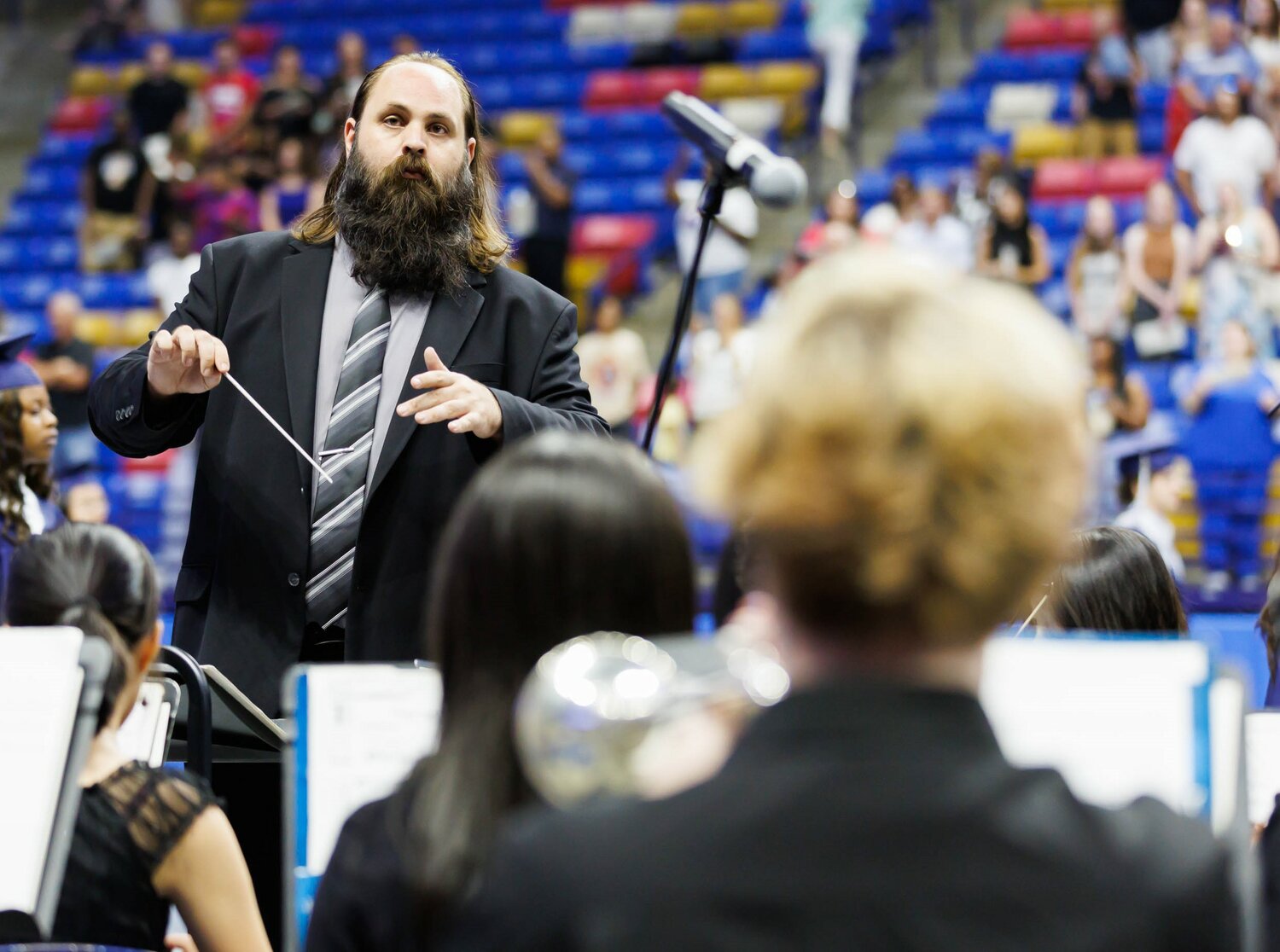 The director leads the band during the Terry Sanford High School 2023 commencement Wednesday at the Crown Coliseum.
