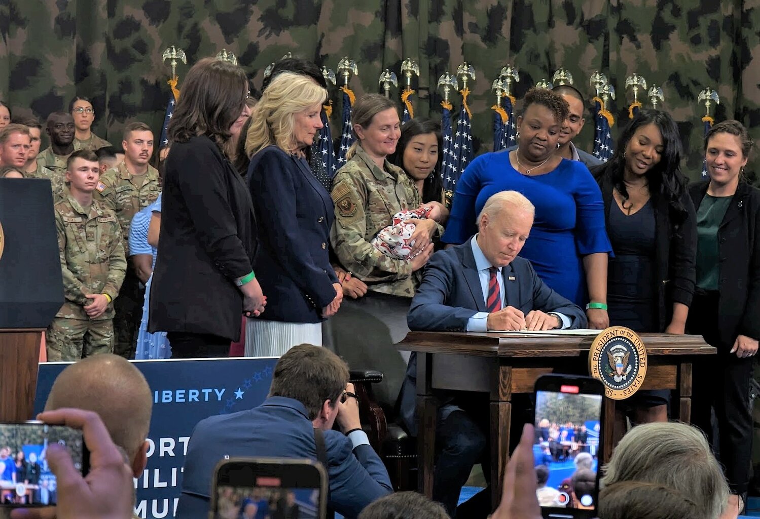 President Joe Biden on Friday signs the executive order as first lady Jill Biden and military personnel and their families watch.