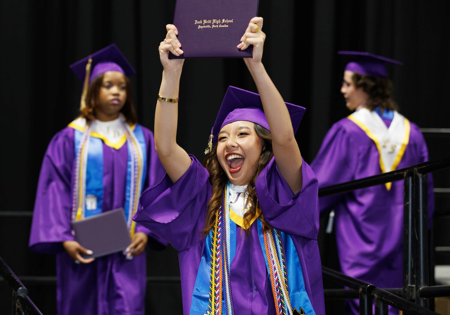 A graduate celebrates her diploma at the Jack Britt High School 2023 commencement Wednesday at the Crown Coliseum.