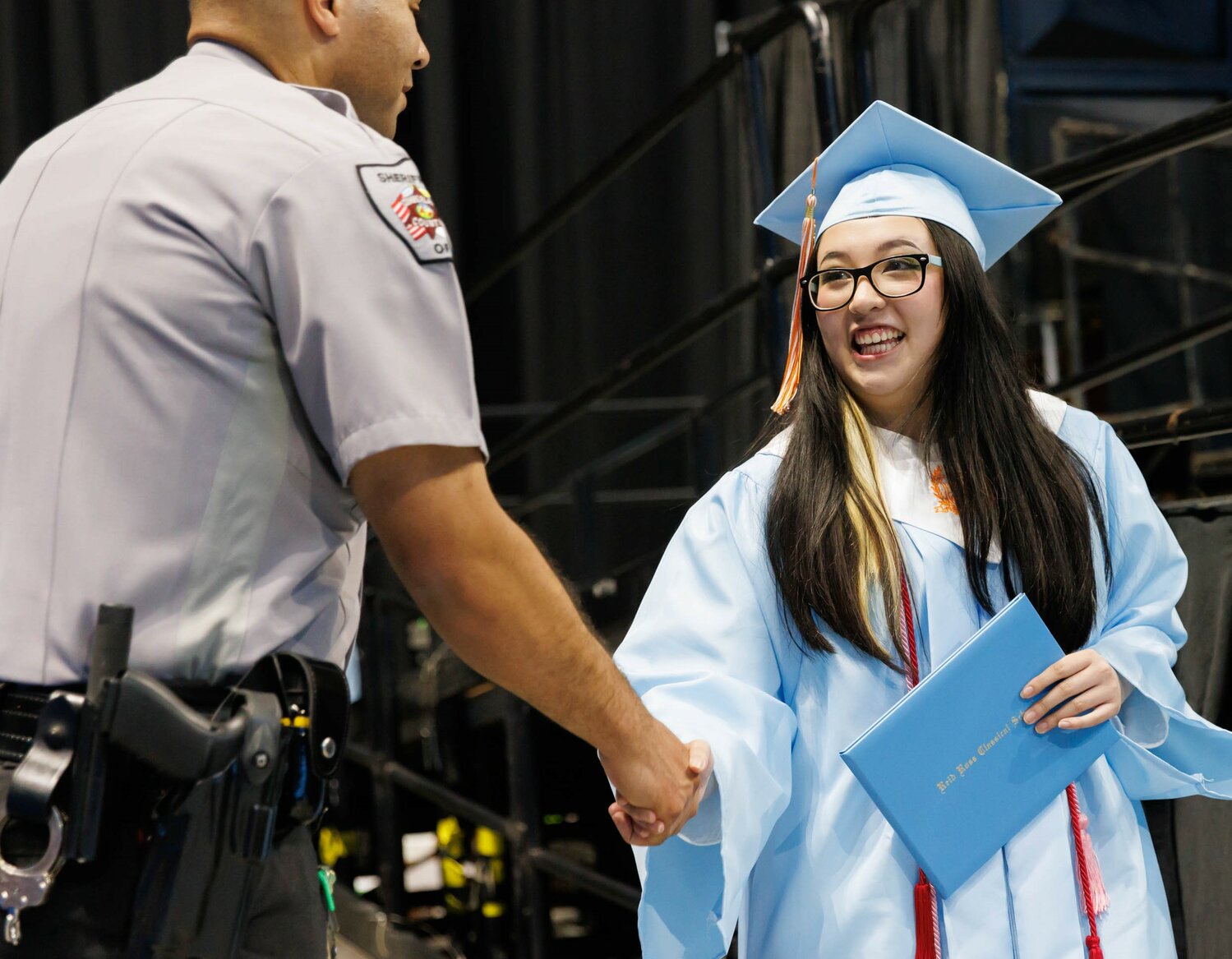 A law enforcement officer congratulates a graduate at the 2023 commencement for Reid Ross Classical High School was held at the Crown Coliseum on Wednesday.