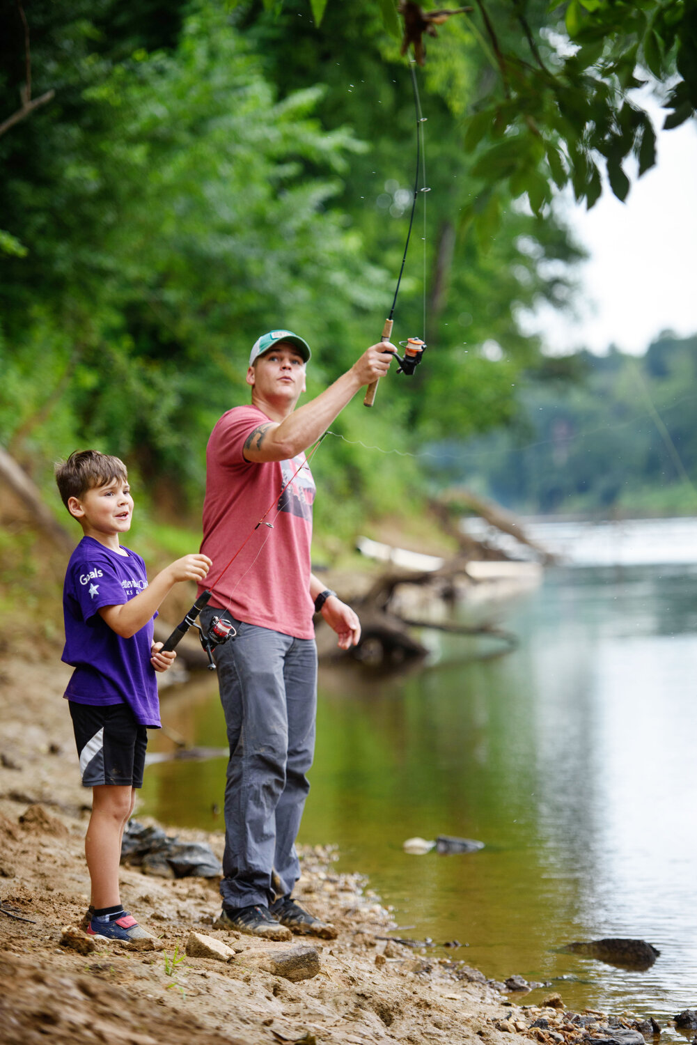 Roman Stophel watches his dad, Nathan Stophel, try his luck reeling in a catfaish and bluegill on the Cape Fear River.
