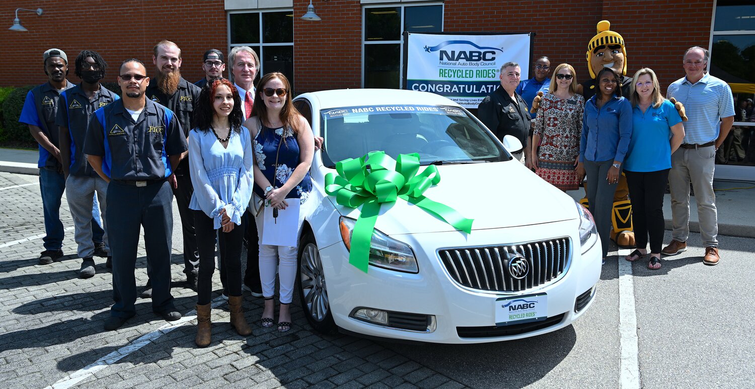 Students and donors who contributed to the repair and refurbishment of the vehicle congratulate Sarah Taylor after it was presented to her.