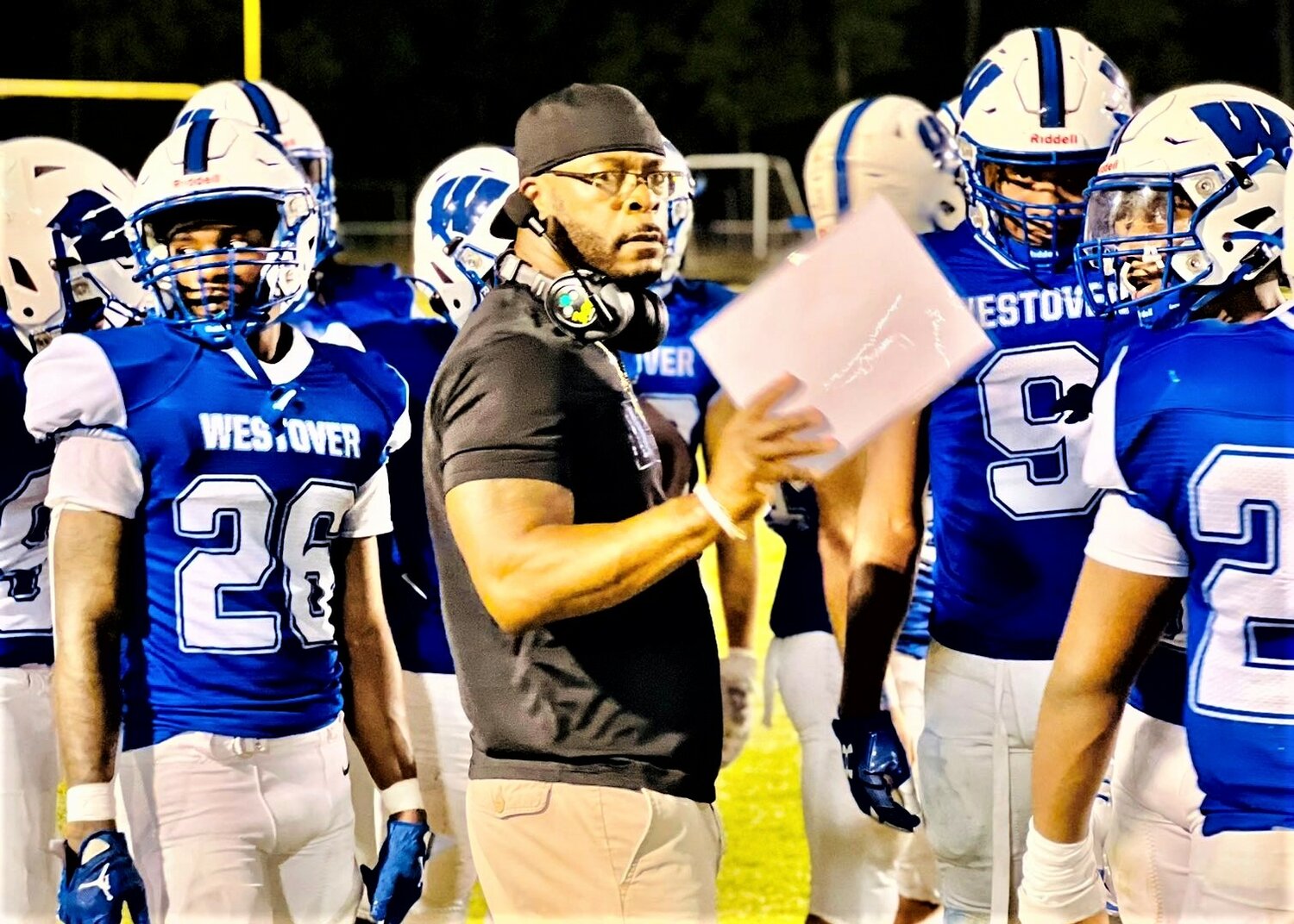 Coach Ernest King huddles with his players on the Westover High football team.