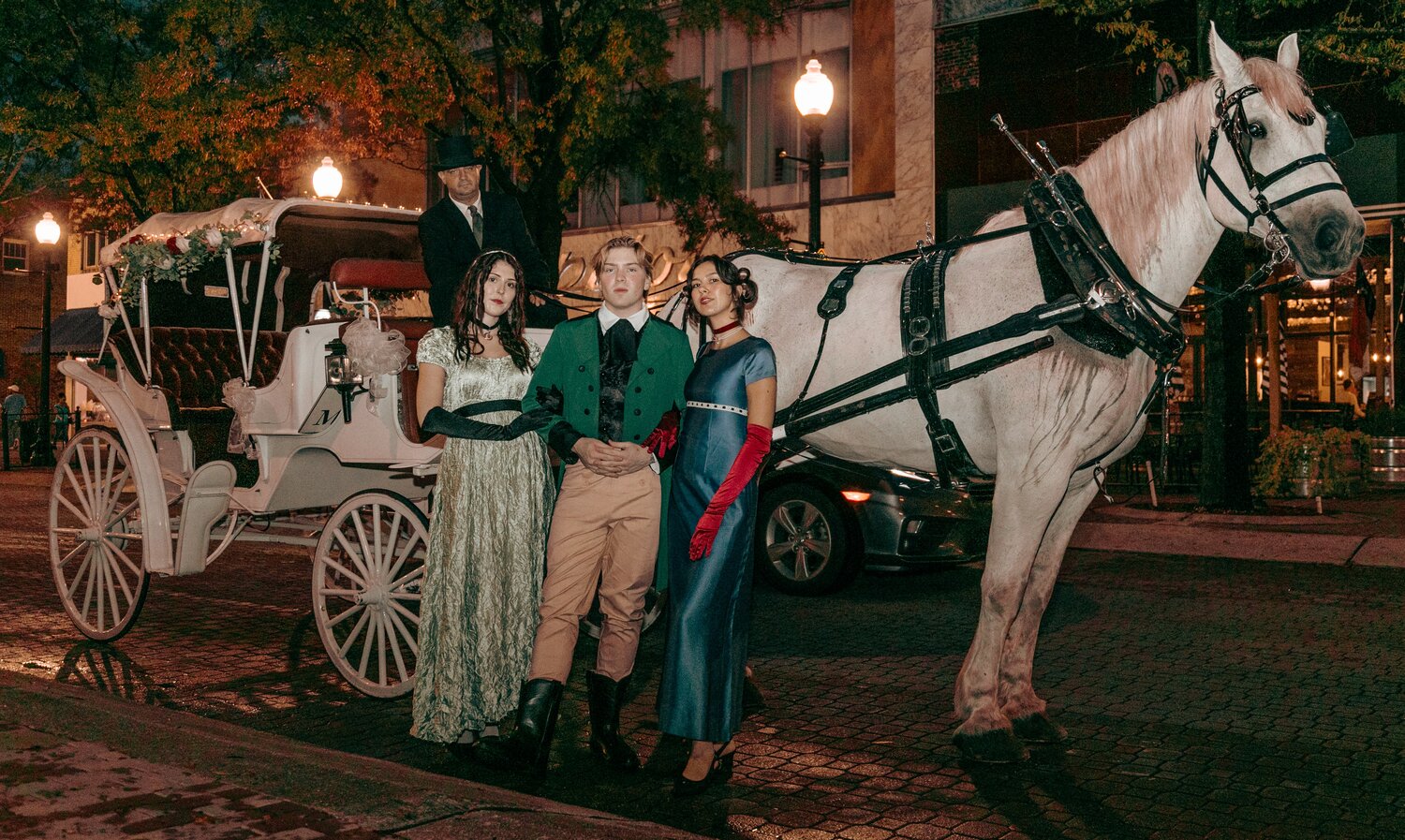 Tara Rochelle Cathey, Mark Peters and Ally Merino arrive by horse and carriage for Lafayette's Grand Birthday Ball on Saturday in downtown Fayetteville.