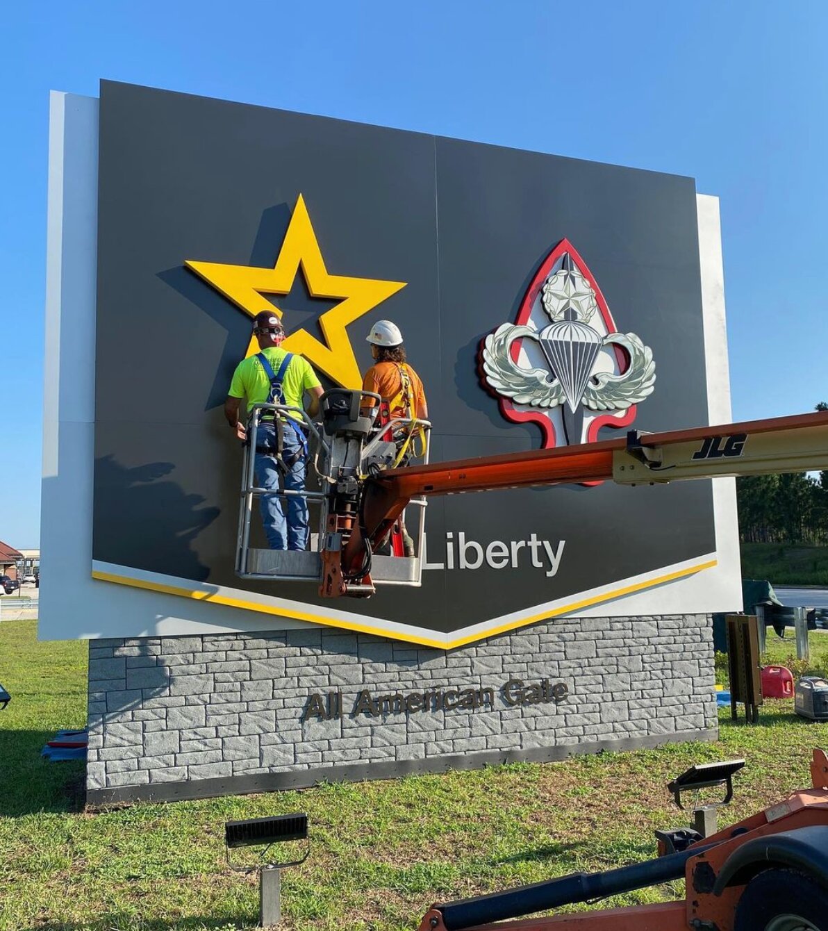 Workers put the final touches on one of the major access point signs at Fort Liberty.