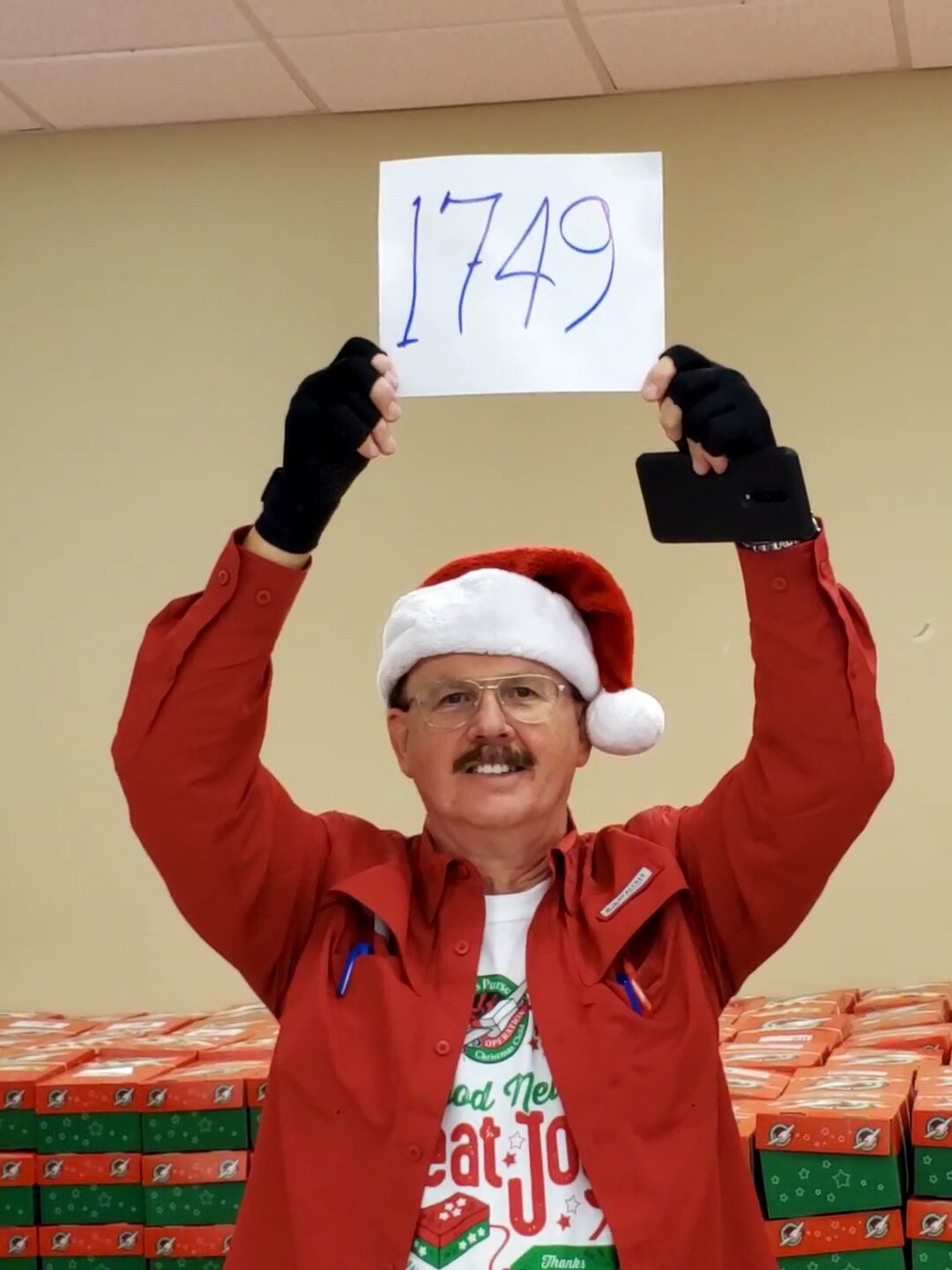 Reverend Allen Gayle, Pamela Gayle's husband, displays the total number of boxes — 1,749 — packed during the 2021 packing party. Last year the group packed 2,068 boxes.