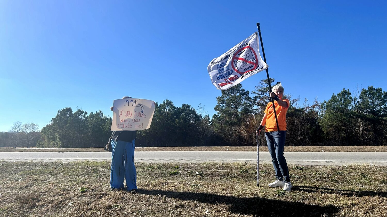 Protestors hold up signs outside the entrance to the Chemours factory in Gray's Creek.