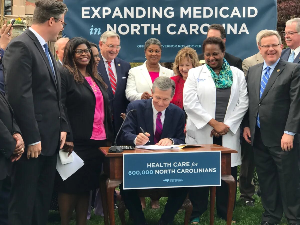 N.C. Gov. Roy Cooper signs Medicaid expansion into law on March 27, 2023.