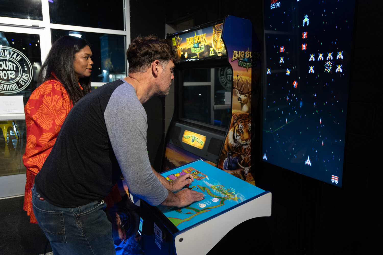 Samantha Kovalev watches as her friend Shane Booth play Galaga during the soft opening on Wednesday of the Haymount Truck Stop food truck court and bar. The Truck Stop is Fayetteville’s first food truck court.